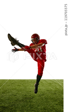 Full-length vertical image of man, American football player in red uniform in motion on field, training with intensity and focus Full-length vertical image of man, American football player in red uniform in motion on field, training with intensity and focus 119703375