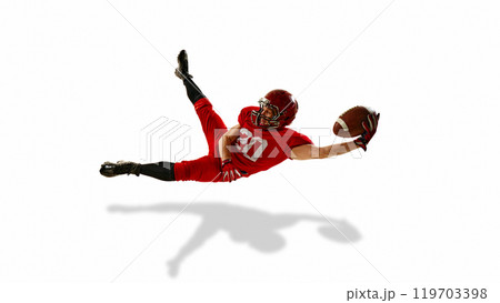Focused man, American football player in red uniform in motion, catching the ball in mid-air, training isolated on white background Focused man, American football player in red uniform in motion, catching the ball in mid-air, training isolated on white background 119703398
