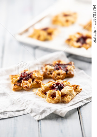 Sweet dessert pastries made of puff pastry with strawberry jam filled with caramelized apple Sweet dessert pastries made of puff pastry with strawberry jam filled with caramelized apple 119703764