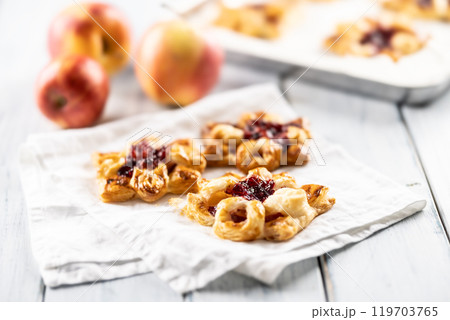 Sweet dessert pastries made of puff pastry with strawberry jam filled with caramelized apple Sweet dessert pastries made of puff pastry with strawberry jam filled with caramelized apple 119703765