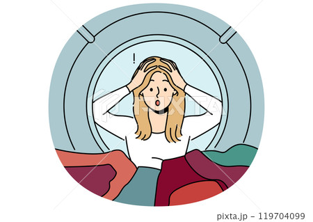 Woman housewife peeks into washing machine and grabs head after seeing ruined clothes 119704099
