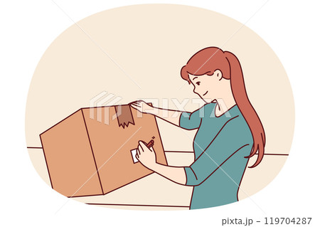 Woman with cardboard box signs package before sending goods through postal service or courier 119704287