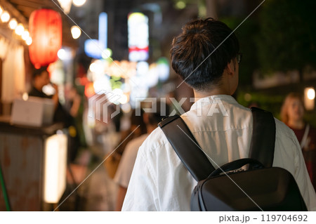 夜の街中を歩く男性 119704692