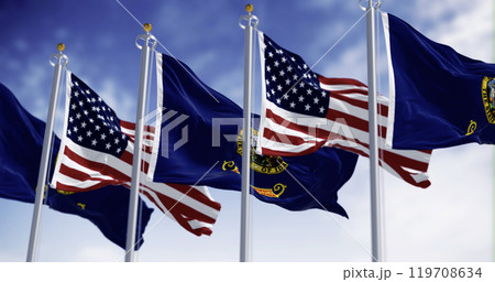 Idaho state flags waving along with the national flags of the US on a clear day. 119708634