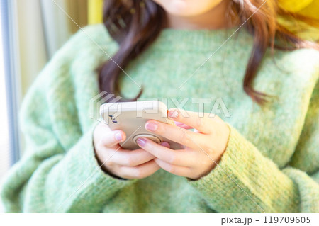 スマホ操作をする女性の手元02 スマホ操作をする女性の手元02 119709605
