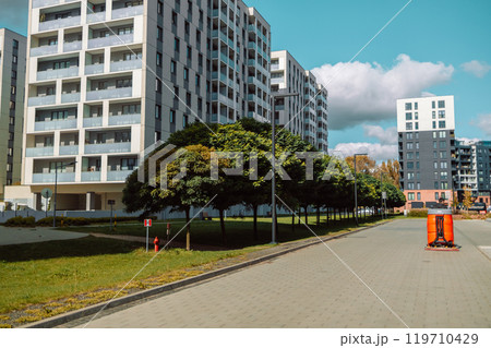 Cityscape of a residential area with modern apartment buildings, new green urban landscape in the city.Street cleaner, road sweeper cleaning on the floor in city of Krakow, Poland.  119710429