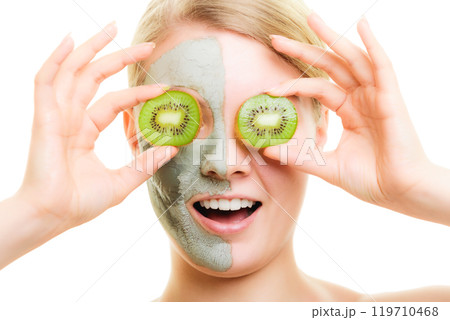 Skin care. Woman in clay mask with kiwi on face 119710468