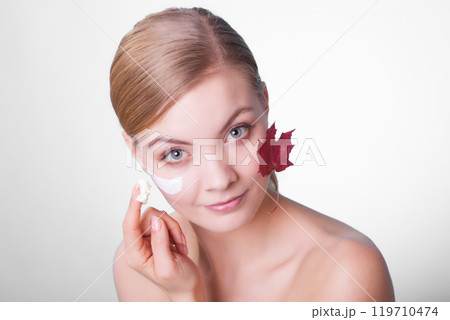 Skin care. Face of young woman girl with red maple leaf. Skin care. Face of young woman girl with red maple leaf. 119710474