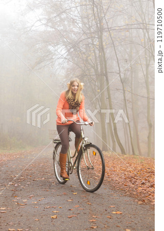 Active woman riding bike bicycle in autumn park. Active woman riding bike bicycle in autumn park. 119710500