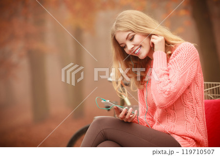 girl listening to music in autumn park 119710507