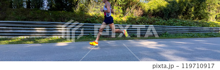 side view athlete runner running marathon race on asphalt road 119710917