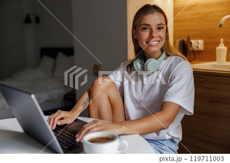 A Young Woman Enjoying Her Work from Home in a Relaxed, Modern Lifestyle Environment A Young Woman Enjoying Her Work from Home in a Relaxed, Modern Lifestyle Environment 119711003
