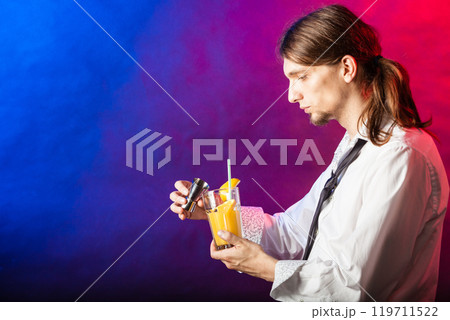 Barman mixing beverages in glass. 119711522