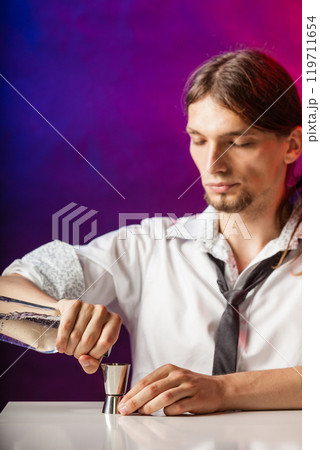 Barman fills shot glass. Barman fills shot glass. 119711654