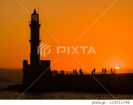 夕焼けの中の古い灯台のシルエット (ギリシャ、クレタ島、ハニア旧市街) 夕焼けの中の古い灯台のシルエット (ギリシャ、クレタ島、ハニア旧市街) 119711748