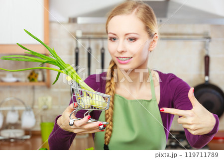 Woman holding shopping cart with chive inside 119711789