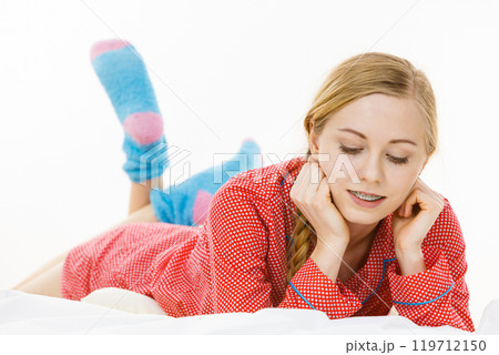 Smiling woman lying in bed Smiling woman lying in bed 119712150