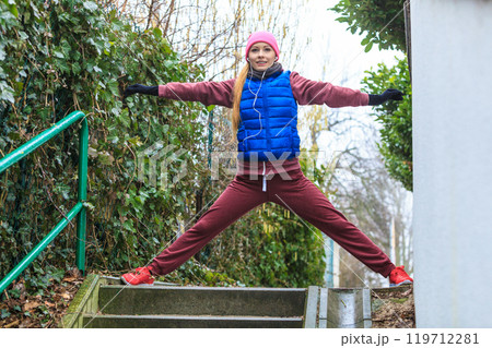 Woman wearing sportswear exercising outside during autumn Woman wearing sportswear exercising outside during autumn 119712281