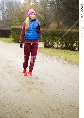 Woman wearing sportswear exercising outside during autumn 119712284