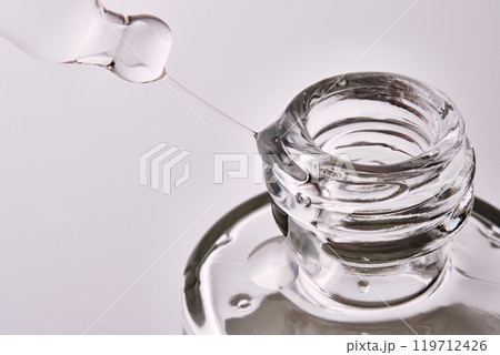 Close-up of a cosmetic bottle with a pipette showing the texture of the serum. 119712426