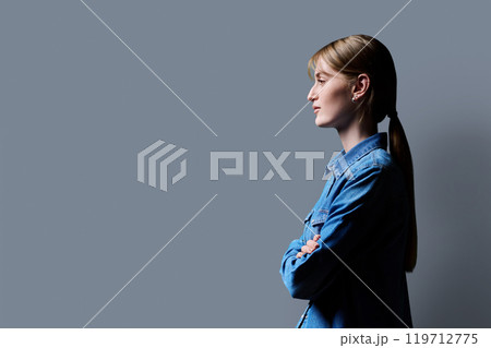 Profile view, confident young smiling teenage woman, copy space gray background Profile view, confident young smiling teenage woman, copy space gray background 119712775