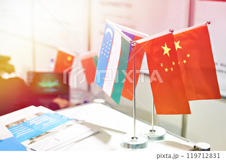 Flags of China and Uzbekistan at business exhibition 119712831