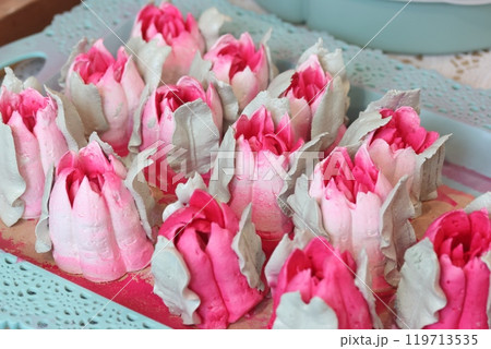 Marshmallow tulips. Marshmallow flowers. Spread out on the table surface. Close-up. Marshmallow tulips. Marshmallow flowers. Spread out on the table surface. Close-up. 119713535