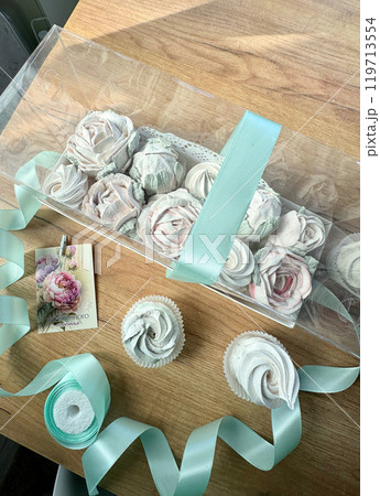 Marshmallow flowers in a gift box with a transparent lid. A card with the inscription in Russian Endless happiness. 119713554