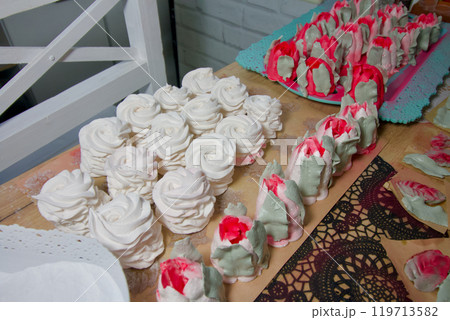 Homemade marshmallows are spread out on the table surface. They are setting and stabilizing before packaging. The marshmallows are classic. Marshmallow tulips. Homemade marshmallows are spread out on the table surface. They are setting and stabilizing before packaging. The marshmallows are classic. Marshmallow tulips. 119713582