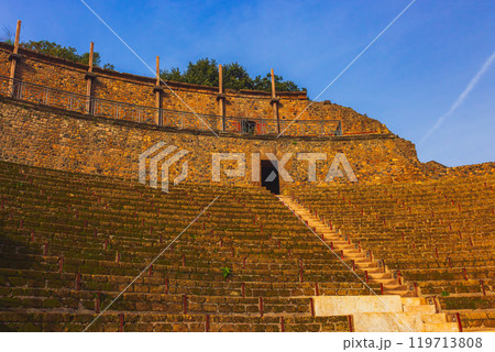 An ancient amphitheater beautifully surrounded by lush greenery, enriching the scene. City of Pompei 119713808