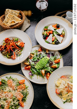 Gourmet salads with various ingredients including avocado, feta, grilled vegetables and salmon 119714102