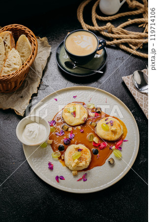 Gourmet pancakes with caramel sauce, fresh fruits, edible flowers, and sour cream Gourmet pancakes with caramel sauce, fresh fruits, edible flowers, and sour cream 119714106
