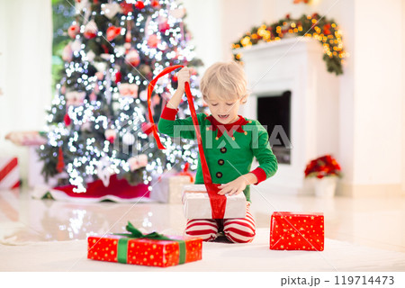 Child at Christmas tree. Kids at fireplace on Xmas 119714473