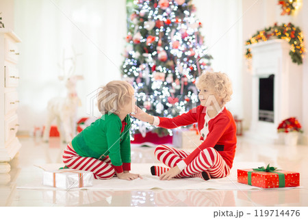 Child at Christmas tree. Kids at fireplace on Xmas 119714476