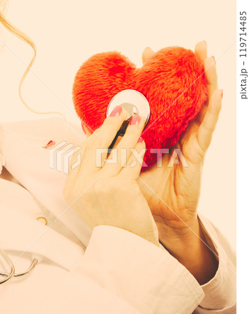 Doctor with stethoscope examining red heart. 119714485