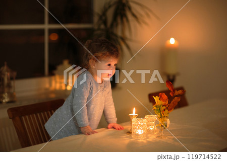 Child at home with candle and autumn decoration Child at home with candle and autumn decoration 119714522