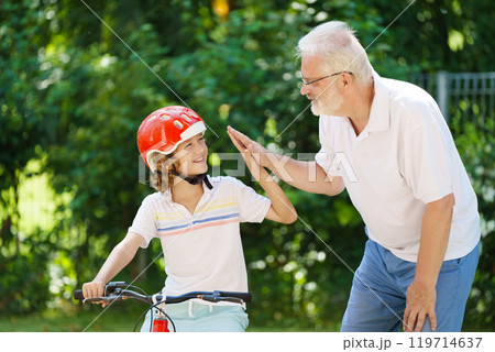 Grandfather and kids in sunny garden Grandfather and kids in sunny garden 119714637