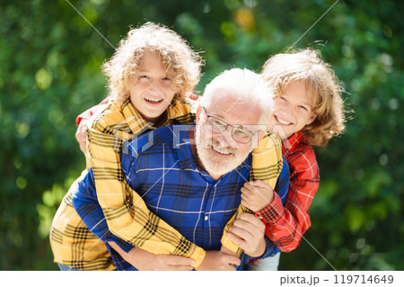 Grandfather and kids in sunny garden Grandfather and kids in sunny garden 119714649