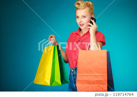Pinup girl with shopping bags calling on phone Pinup girl with shopping bags calling on phone 119714764