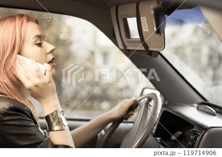 girl talking on mobile phone while driving the car. girl talking on mobile phone while driving the car. 119714906