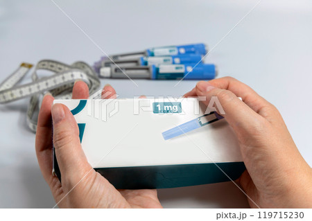 Hands holding Ozempic Insulin injection pen for diabetics and weight loss. Medical equipment for diabetes parients. 119715230