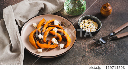 Baked pumpkin with ricotta and rosemary on a plate on the table web banner Baked pumpkin with ricotta and rosemary on a plate on the table web banner 119715298