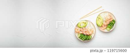 Two white ceramic bowls with rice, shrimps, avocado, vegetables and sesame seeds and wooden sticks on white concrete stone background top view. Healthy asian style poke bowl, space for text Two white ceramic bowls with rice, shrimps, avocado, vegetables and sesame seeds and wooden sticks on white concrete stone background top view. Healthy asian style poke bowl, space for text 119715600