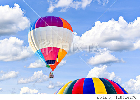Colorful hot air balloon flying over blue sky with white clouds	 119716276