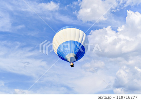 Colorful hot air balloon flying over blue sky with white clouds	 119716277