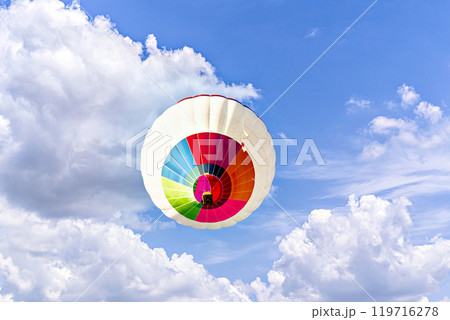Colorful hot air balloon flying over blue sky with white clouds Colorful hot air balloon flying over blue sky with white clouds 119716278