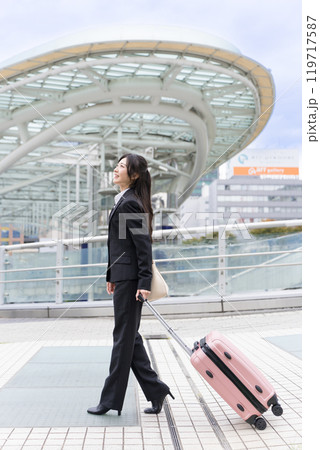 スーツケースを牽いて名古屋に出張する若いビジネスウーマン スーツケースを牽いて名古屋に出張する若いビジネスウーマン 119717587