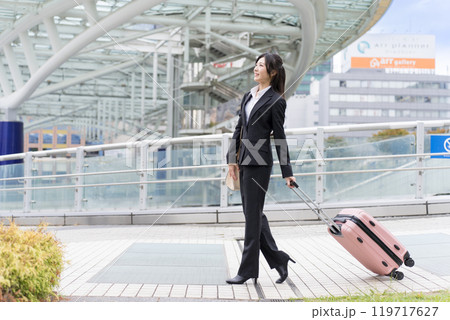スーツケースを牽いて名古屋に出張する若いビジネスウーマン スーツケースを牽いて名古屋に出張する若いビジネスウーマン 119717627