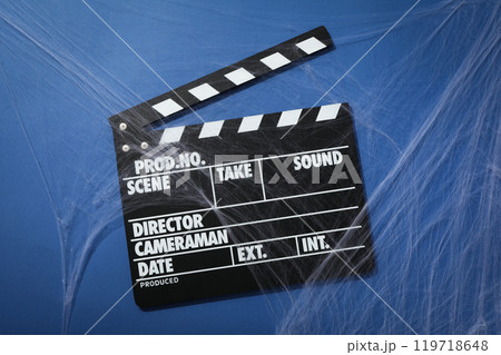 Clapperboard and spider web on blue background, top view Clapperboard and spider web on blue background, top view 119718648