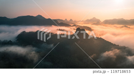 Aerial View of Morning fog and mountains as the sun rises from above 119718653